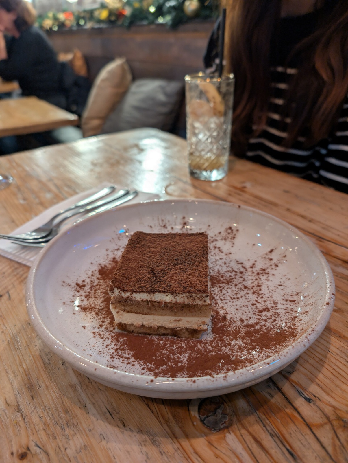 Part de tiramisu maison avec ses couches de crème mascarpone, biscuits imbibés de café et voile de cacao amer