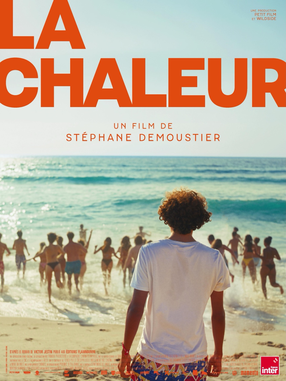 Affiche du film La Chaleur de Stéphane Demoustier : un adolescent de dos sur une plage des Landes regarde des jeunes courir vers l'océan