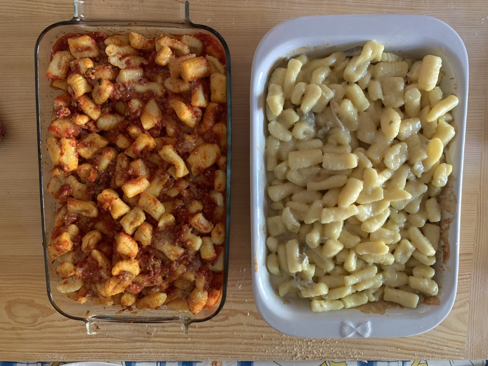 Deux plats de gnocchi de pomme de terre, l'un nappé de sauce tomate et ragù, l'autre au gorgonzola