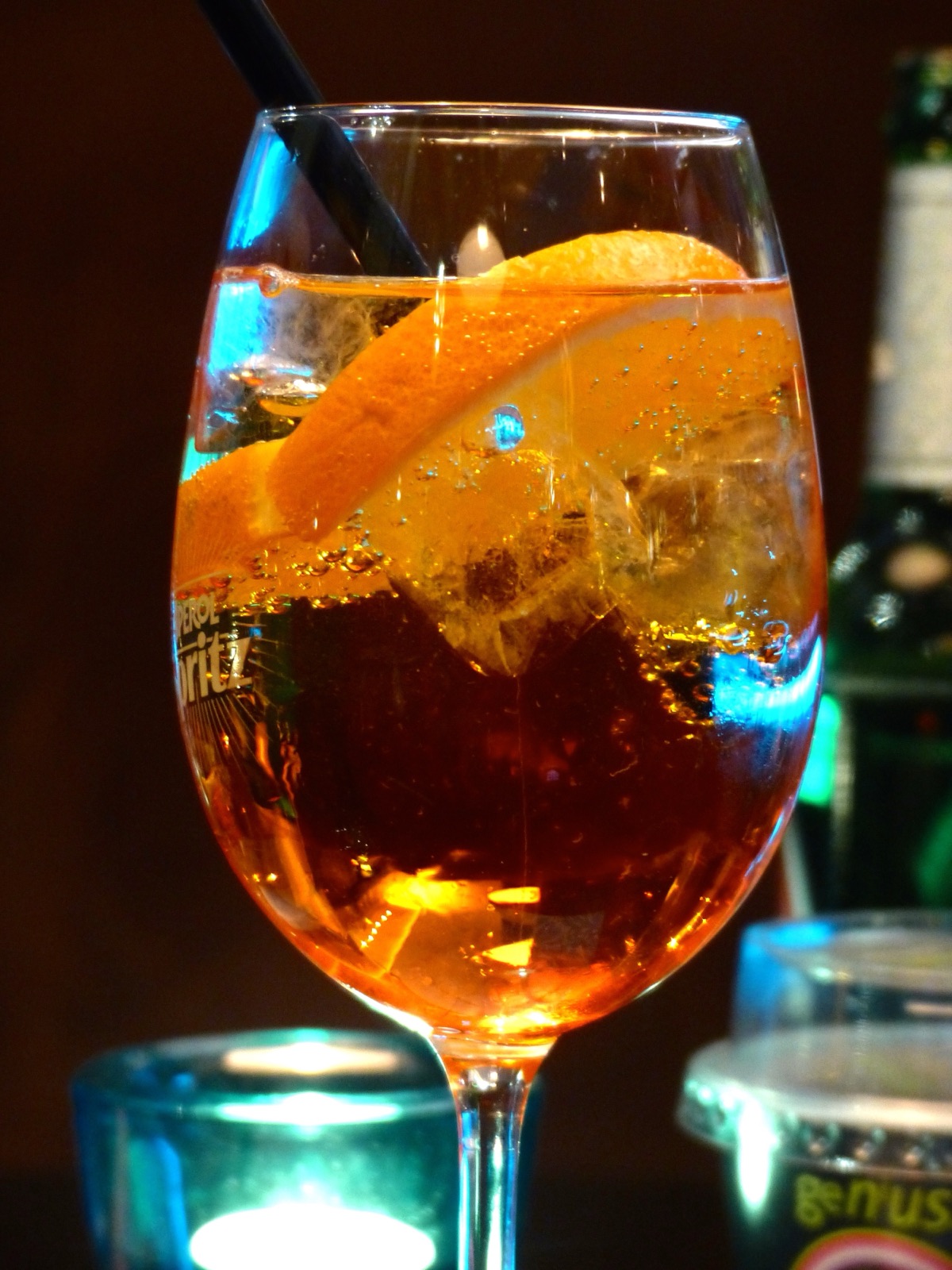 Un verre d'Aperol Spritz avec rondelle d'orange et glaçons sur une table de bar