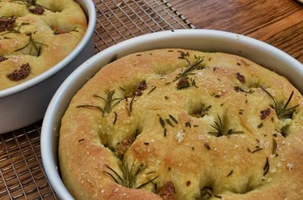 Focaccia maison au romarin et au gros sel, dorée dans son plat rond