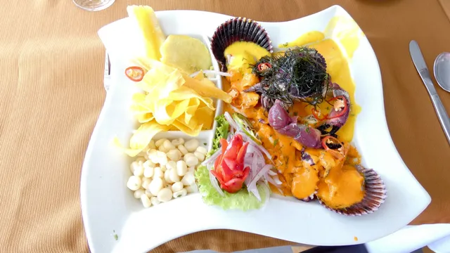Assiette de ceviche péruvien avec poisson mariné, maïs, oignon rouge et chips de banane plantain