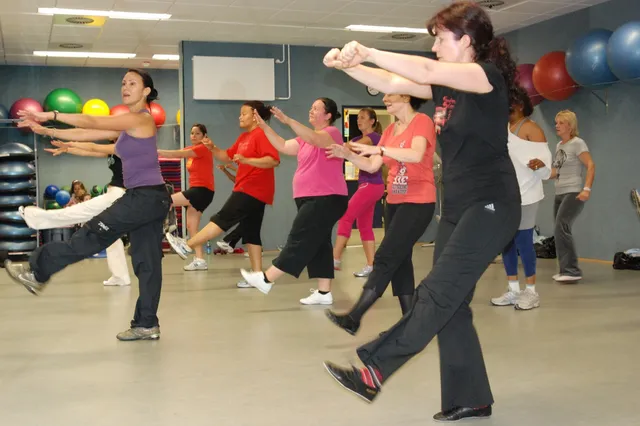 Cours de Zumba en salle, un groupe enchaîne une chorégraphie latine